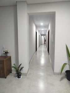 an empty hallway with white walls and white floors and plants at DSá Hotel in Cristalândia
