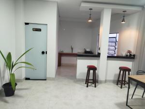 a room with a kitchen with stools and a door at DSá Hotel in Cristalândia