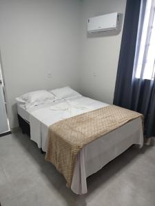 a bedroom with a bed with a blanket on it at DSá Hotel in Cristalândia