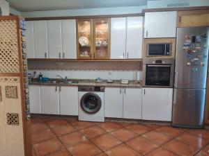 a kitchen with a refrigerator and a washing machine at Casa Kamelias in Moraña