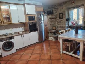 a kitchen with a refrigerator and a table in it at Casa Kamelias in Moraña