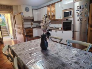 a kitchen with a table with a vase on it at Casa Kamelias in Moraña +36 photos