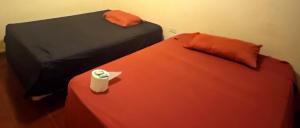 a room with two beds and a red table with a napkin at Entre olas in La Libertad