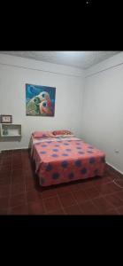 a bed in a room with a painting on the wall at Entre olas in La Libertad