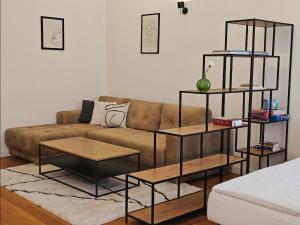 a living room with a brown couch and shelves at ELEVEN APARTMENT - Very Center - Free Parking in Osijek