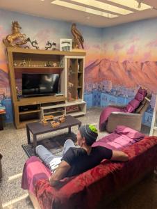 a man laying on a couch in a living room at Peru Hostel Tajmani in Arequipa