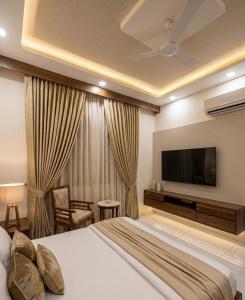 a hotel room with a bed and a flat screen tv at Hotel Nirmal Bhawan Haridwar in Haridwār