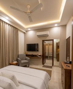 a hotel room with a bed and a television at Hotel Nirmal Bhawan Haridwar in Haridwār +14 photos