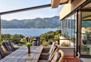 a balcony with a table and chairs and a view of the water at Villa Radman in Korčula