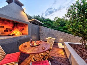 a patio with a table and chairs and a fireplace at Villa Radman in Korčula
