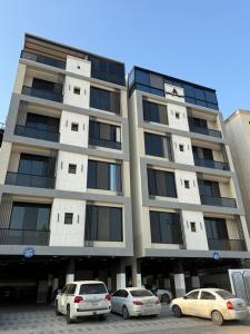 a tall building with cars parked in front of it at Al Hamra Modern Suite, Khobar in Al Khobar