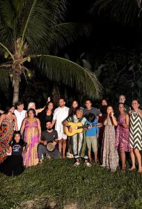 a group of people posing for a picture in front of a palm tree at Hostel Povos da Floresta in Rio Branco