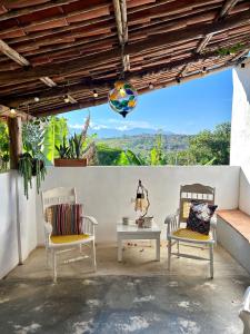 a patio with two chairs and a table with a view at Casa Castañeto Barichara in Barichara
