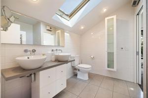 a bathroom with a sink and a toilet and a skylight at Chartres Retreat in Arrowtown +21 photos