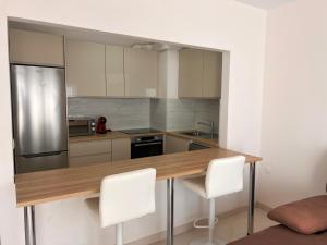 a kitchen with a wooden table and white chairs at Valdés in Callao Salvaje