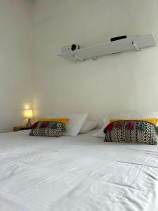 a white bed with two pillows on top of it at Casa Castañeto Barichara in Barichara