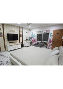 a living room with a couch and a flat screen tv at Raskunj Farm in Noida