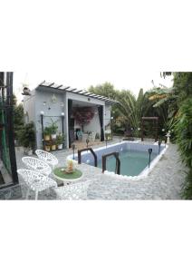a swimming pool with a table and chairs and a house at Raskunj Farm in Noida
