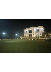 a house with lights on a field at night at Raskunj Farm in Noida