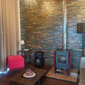 a living room with a brick wall with a stove at Das Glashaus in Curacautín