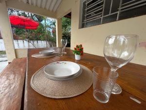 a wooden table with a plate and a wine glass at Chacara c piscina ampla em Pedro de toledo in Pedro de Toledo