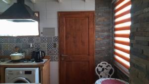 a kitchen with a wooden door and a stove at Manhuemalal in Villarrica +1 photo