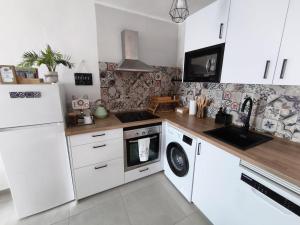 a kitchen with a white refrigerator and a dishwasher at CASA PERSEA in Nerja