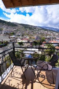 a patio with a table and chairs on a balcony at Alchemist Inn in Gjirokastër