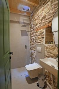 a bathroom with a white toilet and a sink at Alchemist Inn in Gjirokastër +84 photos
