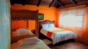 a bedroom with two bunk beds and a window at Las Orquídeas Runtun Lodge in Baños