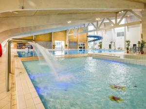 a swimming pool with a fountain in a building at Expansive Villa near Ribe in Skærbæk
