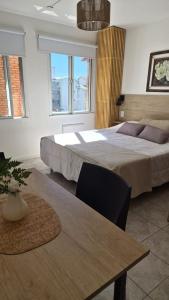 a bedroom with a large bed and a table at Solar Andino Inn in San Carlos de Bariloche