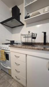 a kitchen with white cabinets and a stove top oven at Solar Andino Inn in San Carlos de Bariloche +30 photos