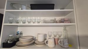 a cupboard filled with glasses and plates and dishes at Solar Andino Inn in San Carlos de Bariloche