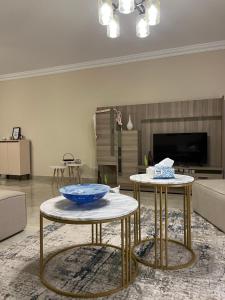 a living room with two tables with a bowl on them at Quiet Comfy Stay in Burg el-Ḥudûd