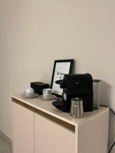 a white desk with a coffee maker and a computer on it at Quiet Comfy Stay in Burg el-Ḥudûd