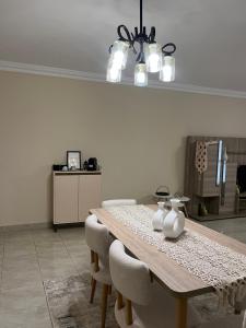 a dining room with a wooden table and chairs at Quiet Comfy Stay in Burg el-Ḥudûd