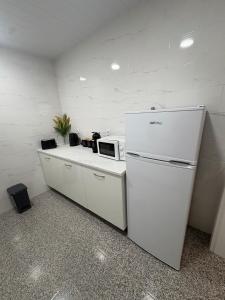 a kitchen with a refrigerator and a microwave on a counter at Casa São Marcos II in Peniche