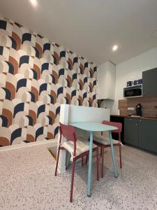 a room with a table and two chairs and a kitchen at Appartement Central avec Jacuzzi Privé I Strasbnb in Strasbourg