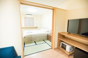 a bedroom with a bed and a sliding glass door at Matsuya hotel in Myoko
