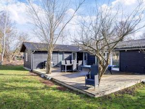 a house with a deck with a table and chairs at 6 person holiday home in Grevinge-By Traum in Grevinge