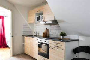 a kitchen with wooden cabinets and a black counter top at Comfortable room with beautiful nature in Malmo in Malmö