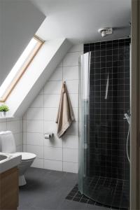 a bathroom with a glass shower in a attic at Comfortable room with beautiful nature in Malmo in Malmö