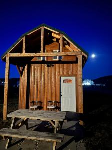 a wooden cabin with two chairs and a door at Cabin 1 The Glacier in Hot Springs