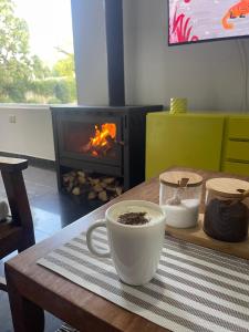 a coffee cup sitting on a table with a fireplace at La escondida in Ramallo