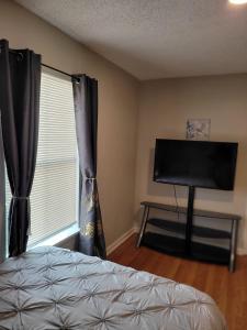 a bedroom with a bed and a window with a television at Everything Bigger in texas in Houston