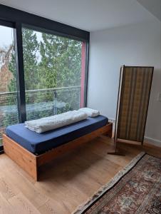 a bed in a room with a large window at Large city apartment with beautiful views in Marburg an der Lahn