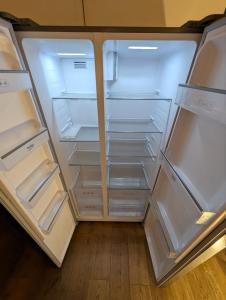 an empty refrigerator with its doors open in a room at Large city apartment with beautiful views in Marburg an der Lahn