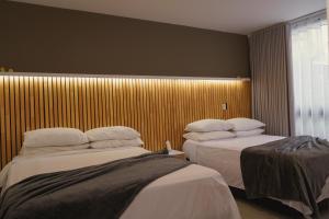 a hotel room with two beds and a window at Luxury Jacuzzi in Poblado in El Poblado