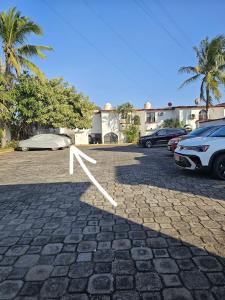 a white arrow on the ground in a parking lot at Casa FLAMINGOS in Boca del Río